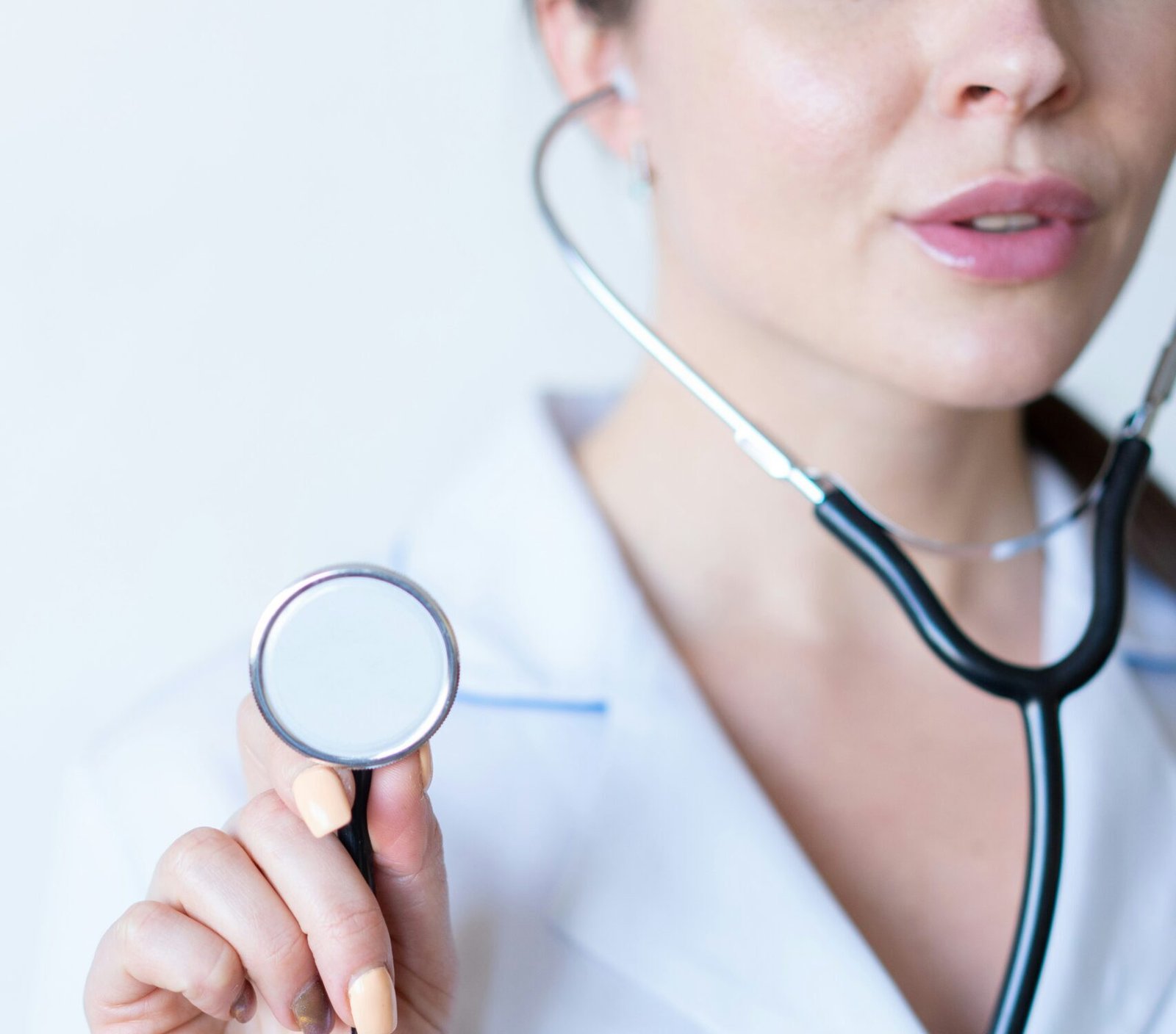 a woman in a white shirt holding a stethoscope