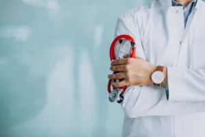 Médico con bata blanca y estetoscopio rojo en la mano, imagen para página web para médicos