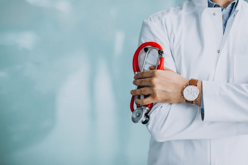 Médico con bata blanca y estetoscopio rojo en la mano, imagen para página web para médicos